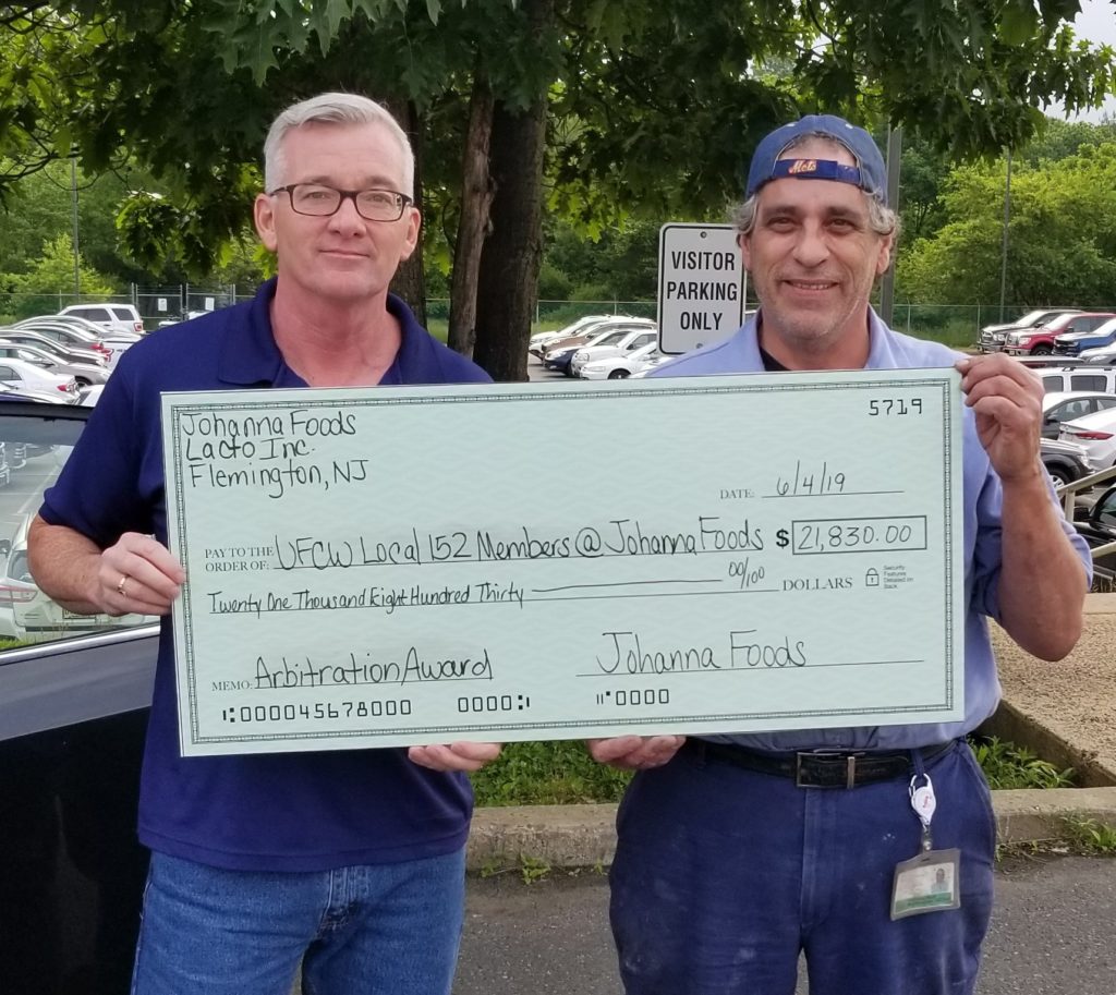 Union Representative Mike Thompson and Shop Steward Tom Noll holding their arbitration award, winning over $20,000 back for members.