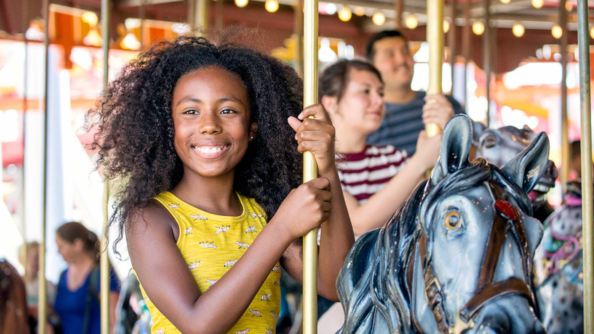 A young girl riding the Antique Carousel at Dorney Park.