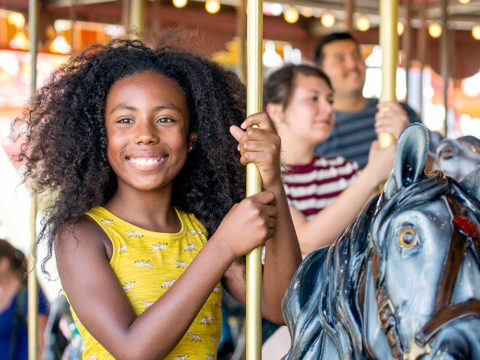 A young girl riding the Antique Carousel at Dorney Park.