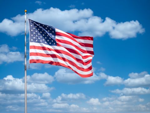 American flag with a sky background